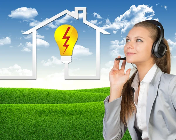Businesswoman in headset, symbol of home energy supply and service beside