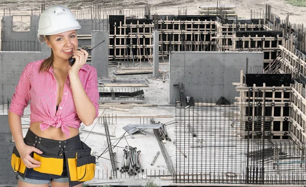 Young woman in hard hat holding walkie talkie