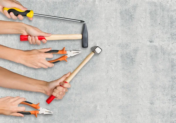 Peoples hands holding tools