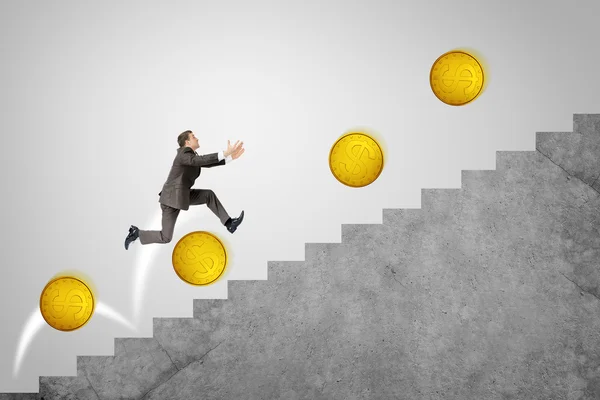 Businessman running up stairs with gold coins