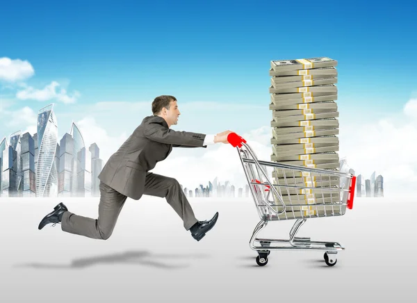 Running businessman with money in shopping cart