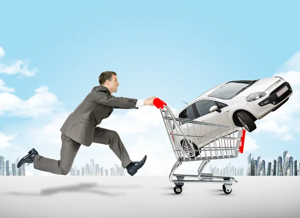 Running businessman with car in shopping cart