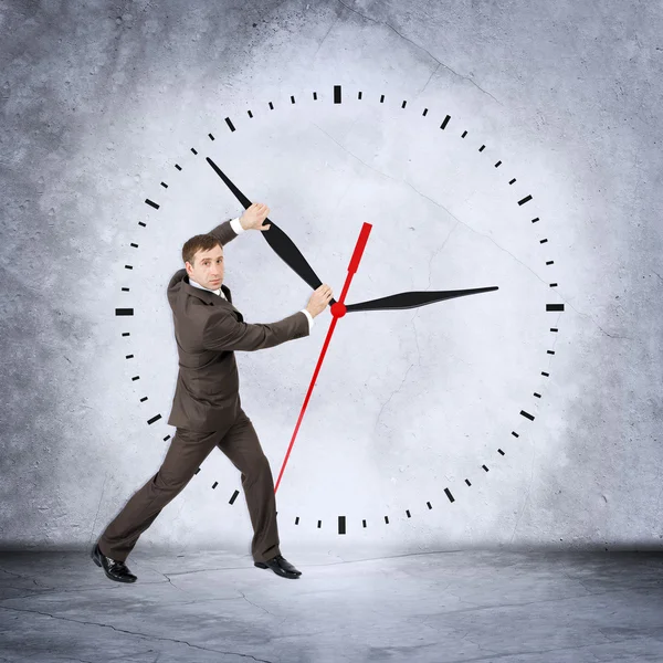 Businessman holding clock hand