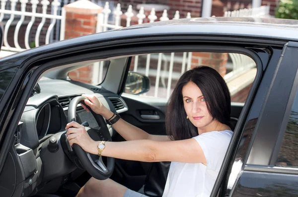 Woman in her late 30s to early 40s in a car happy to have passed the driver license test