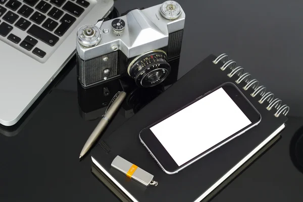 Office table with laptop, phone and supplies