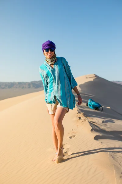 Beautiful young girl walking on the desert