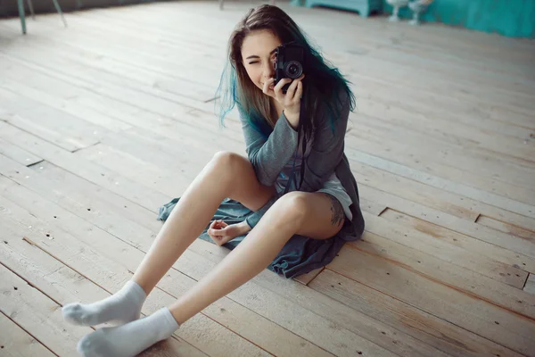 Portrait of pretty young girl taking picture on film camera