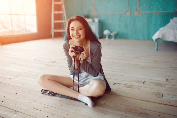 Portrait of pretty young girl taking picture on film camera