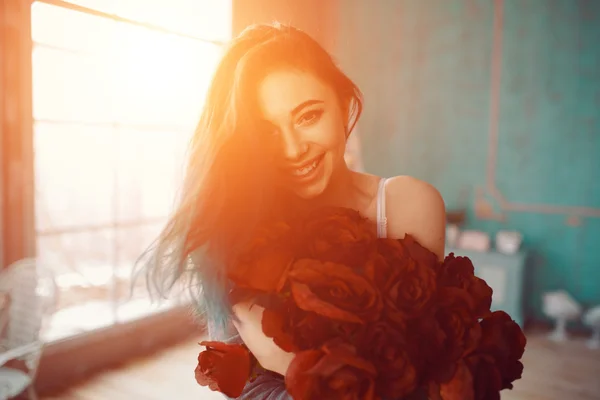 Young and beautiful woman with bouquet of roses