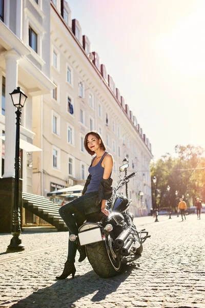 Biker girl in a leather jacket on a motorcycle