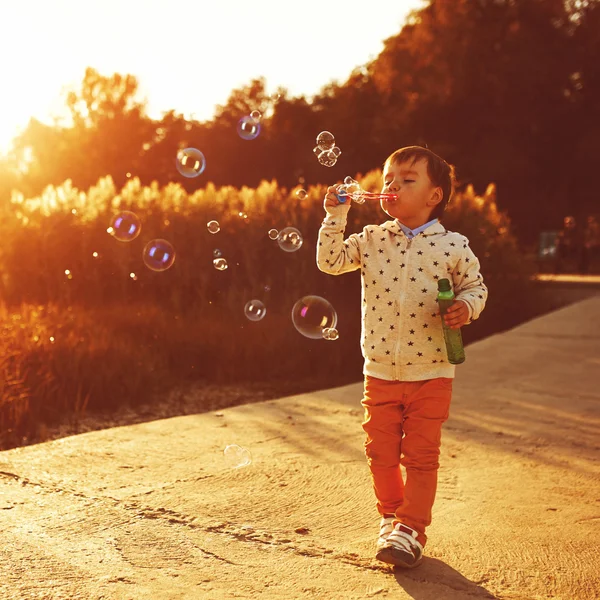 Little boy playing with soap bubbles
