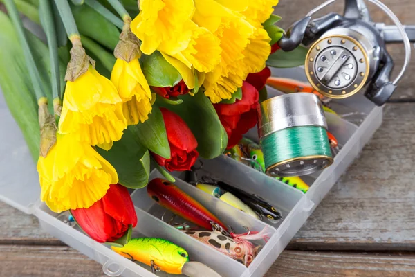Fishing tackles with bouquet spring flowers