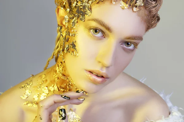 Portrait of beautiful sexy model with gold foil on her face