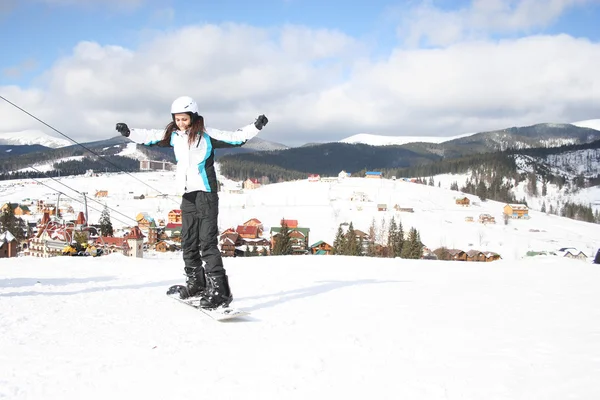 Young Woman snowboarding on the slopes frosty winter day