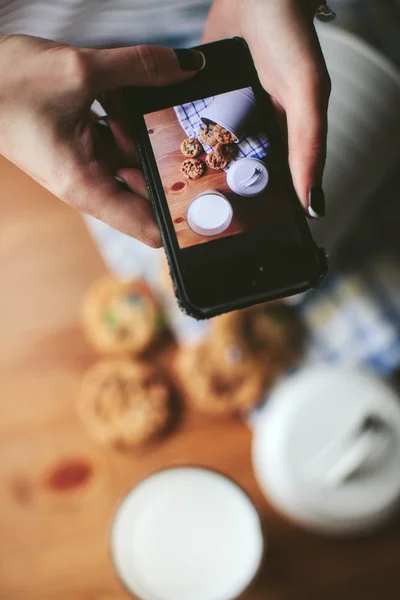 Female hands photographed cookies on your phone