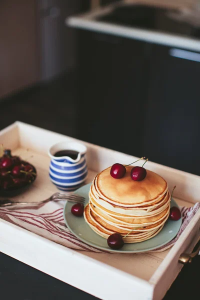 Breakfast of pancakes with a cherry on a tray