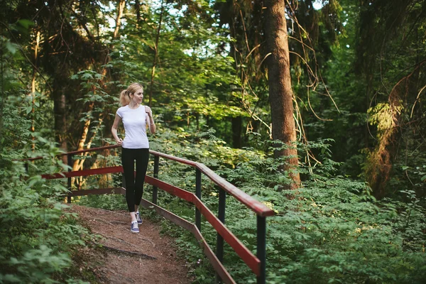 Girl runs along the forest trail