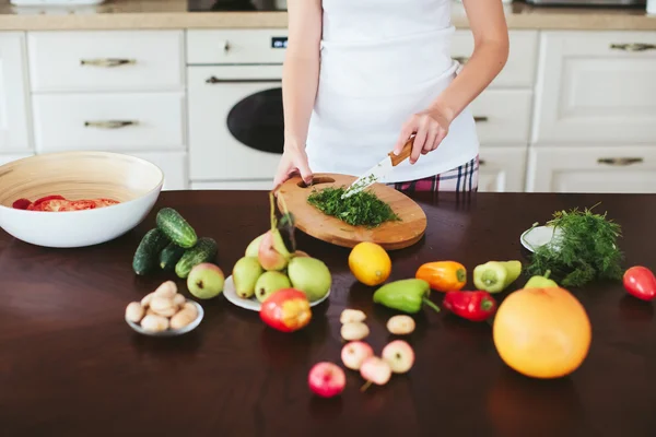 Woman in a home clothes prepares vegetarian. only hands