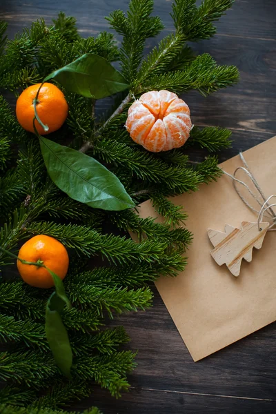 Tangerines on a branch of fir and gift envelope