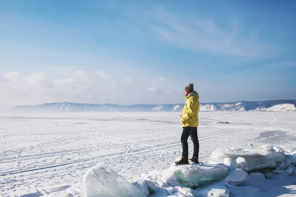 A man standing on the ice fault on a frozen Lake