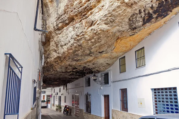 Street with dwellings built into rock overhangs above Rio Trejo.