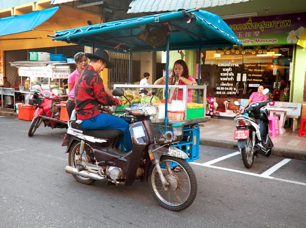 Vendor fast food on a motorcycle serves customers in Hat Yai, Thailand