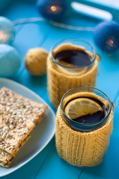 Two cups of delicious tea in knitted sweater yellow on blue back