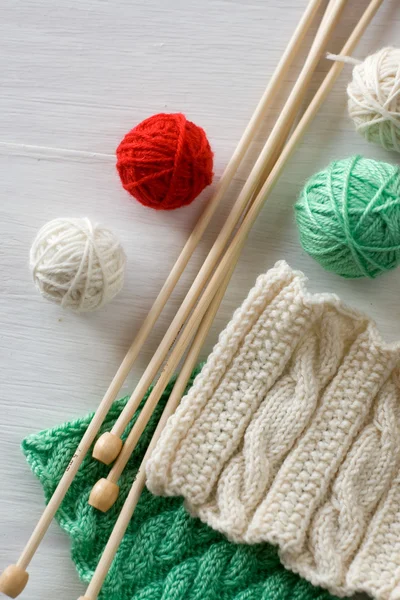 Two bright patterns, yarn balls and needles for knitting wooden