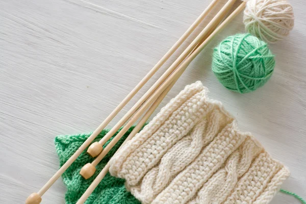 Two bright patterns, yarn balls and needles for knitting