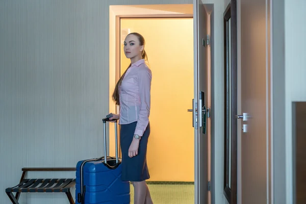 Hotel. Pretty woman with luggage entered into room