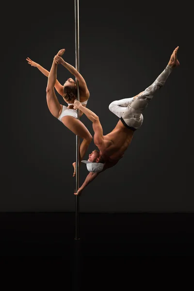 Studio photo of people dancing on pole in pair