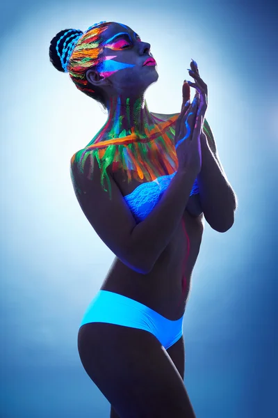 Sexy young woman posing with glowing body art