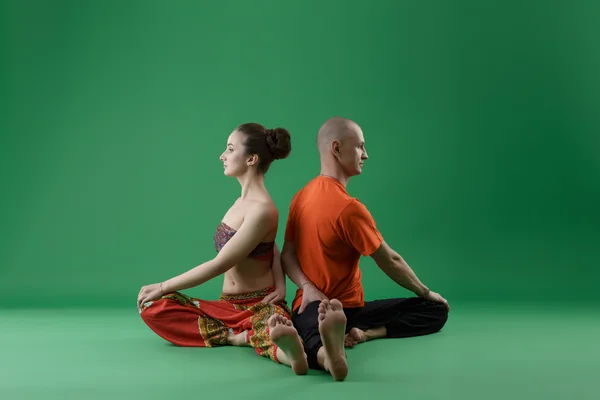 Yoga. Man and woman sitting backs to each other