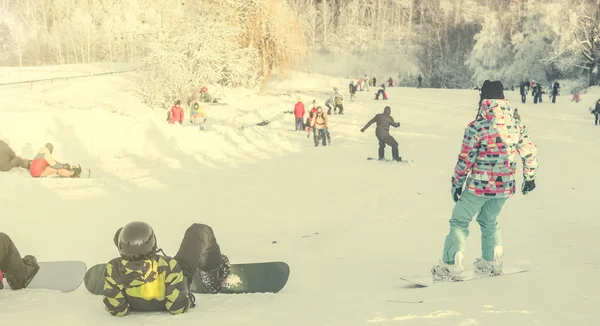 People watching snowboarders on background