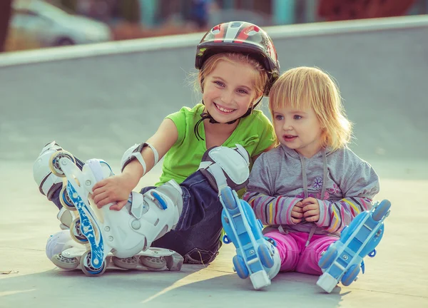 Two little sisters in a roller skates