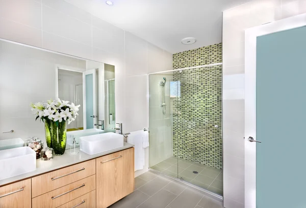 A modern bathroom with white flowers in the vase