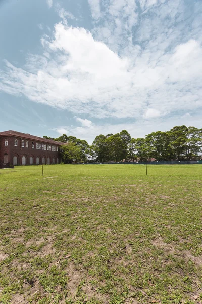 View of a field with a brick house