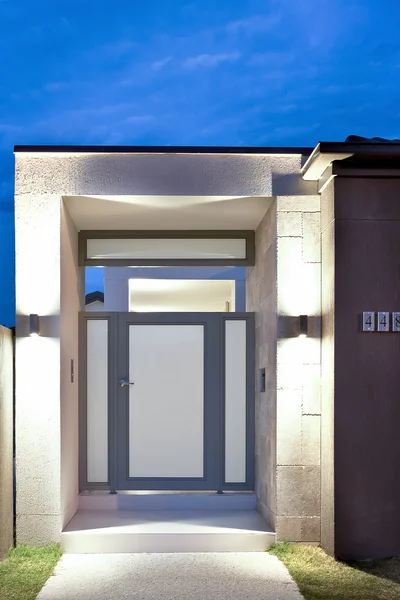 Front of a modern house entrance with lights on