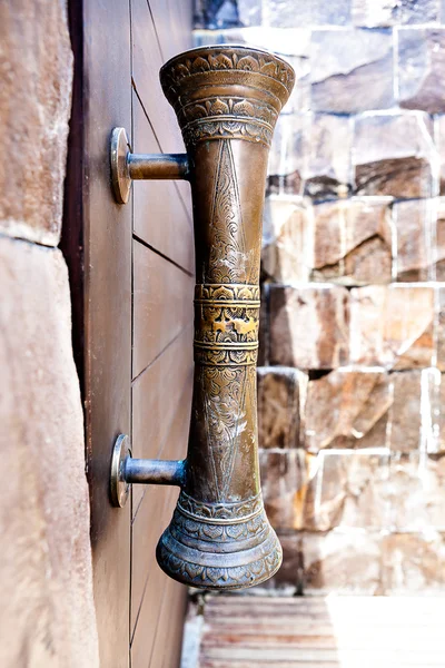 Traditional door handles with a cave on the door