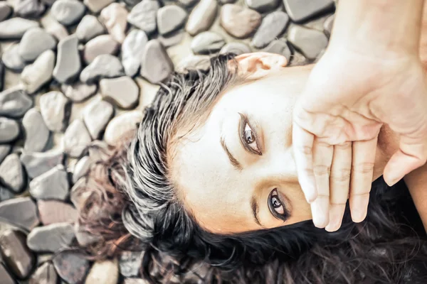 Woman on a stone floor and closed mouth with hands