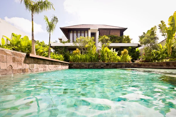 Stone wall water pool closeup with a modern house