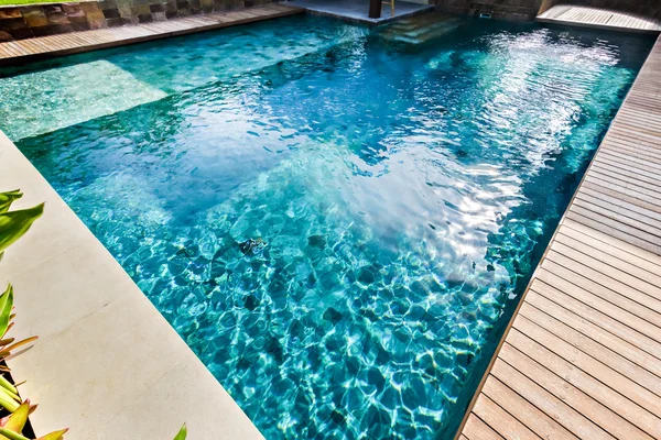 Light blue water swimming pool closeup in a modern house