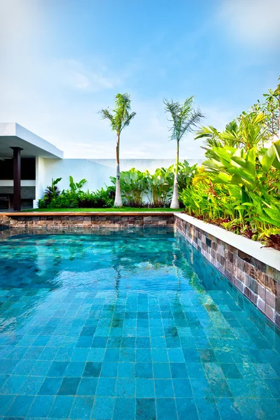 Clear water swimming pool surrounded by brick walls