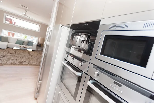 Closeup of modern ovens and a refrigerator in the luxurious kitc