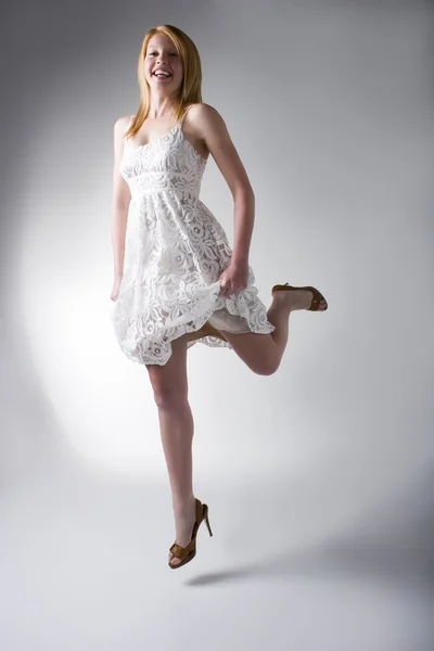 Model in white dress jumping