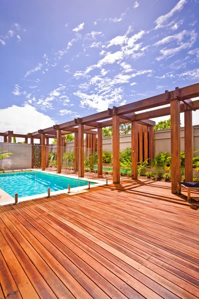 A beautiful view of pool in house in  a sunny day with wooden fl