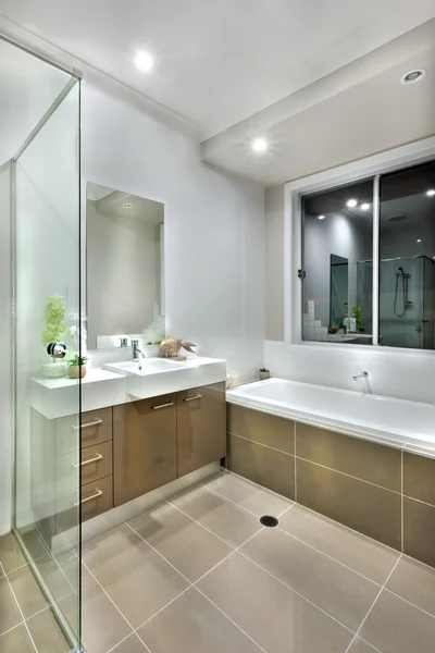 Modern bathroom with dark color floor tiles with lights on