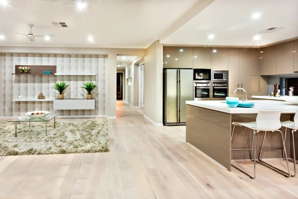 Closeup of a modern kitchen and living room withh lights on