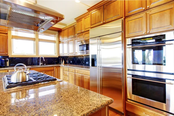 Modern kitchen room interior with wooden cabinets, granite counter top.
