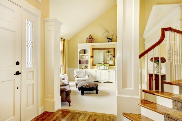 Golden and white golden hallway with beige carpet and columns.